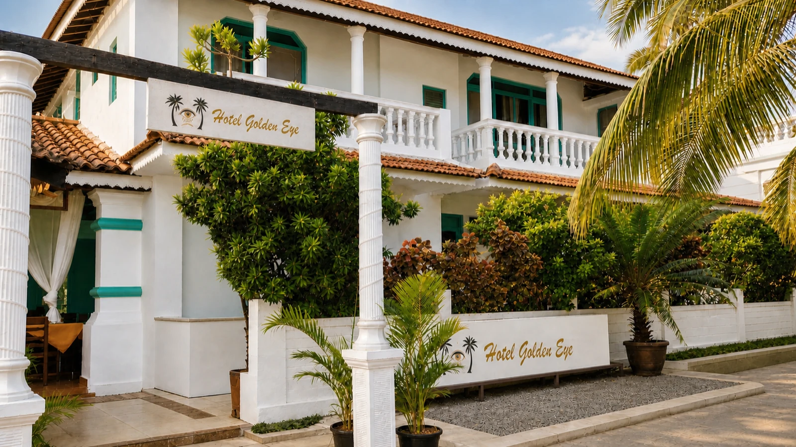 The current white verandahs, turquoise shutters and Hotel Golden Eye sign above the garden in Gaura Waddo.