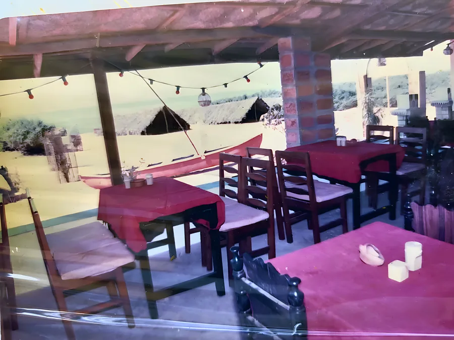 Tables laid under the thatch, string lights up, the sea a few steps that way.