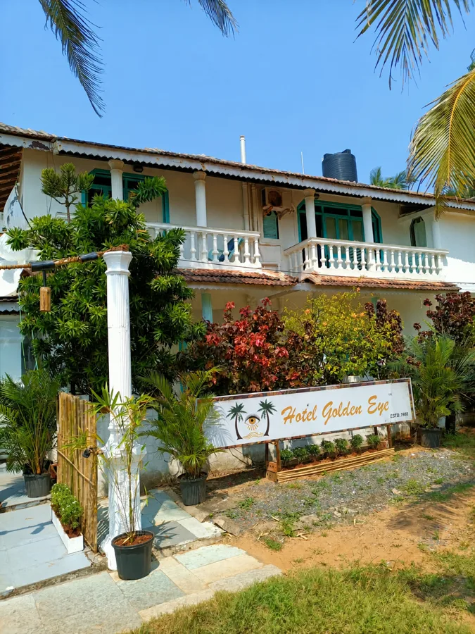 The current white verandahs and turquoise shutters of Hotel Golden Eye above its garden.