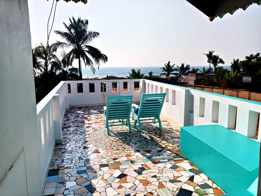 The roof terrace with turquoise chairs and pebble-mosaic paving.
